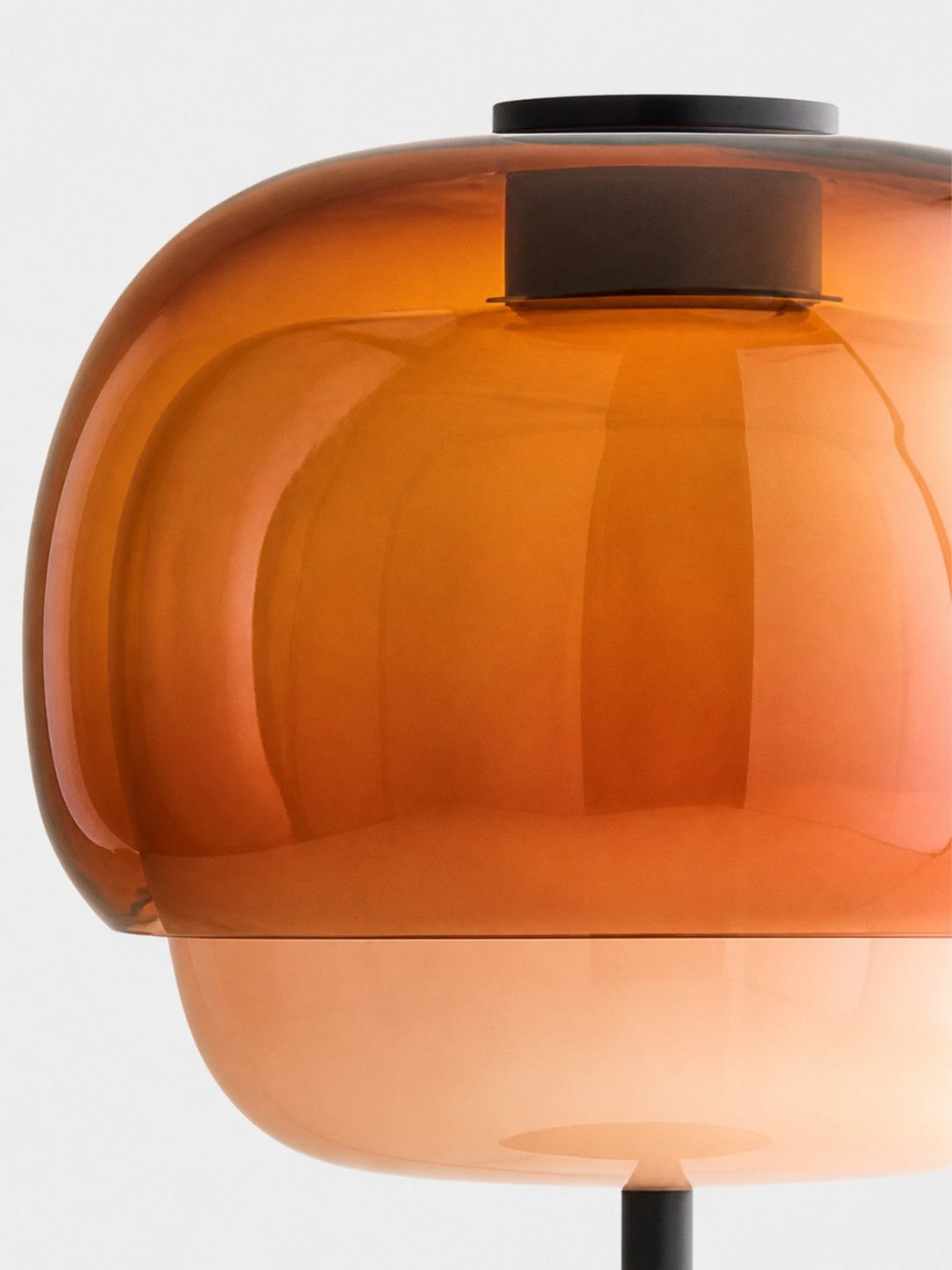 Detailopname van de tweelaagse amberkleurige glazen lampenkap.