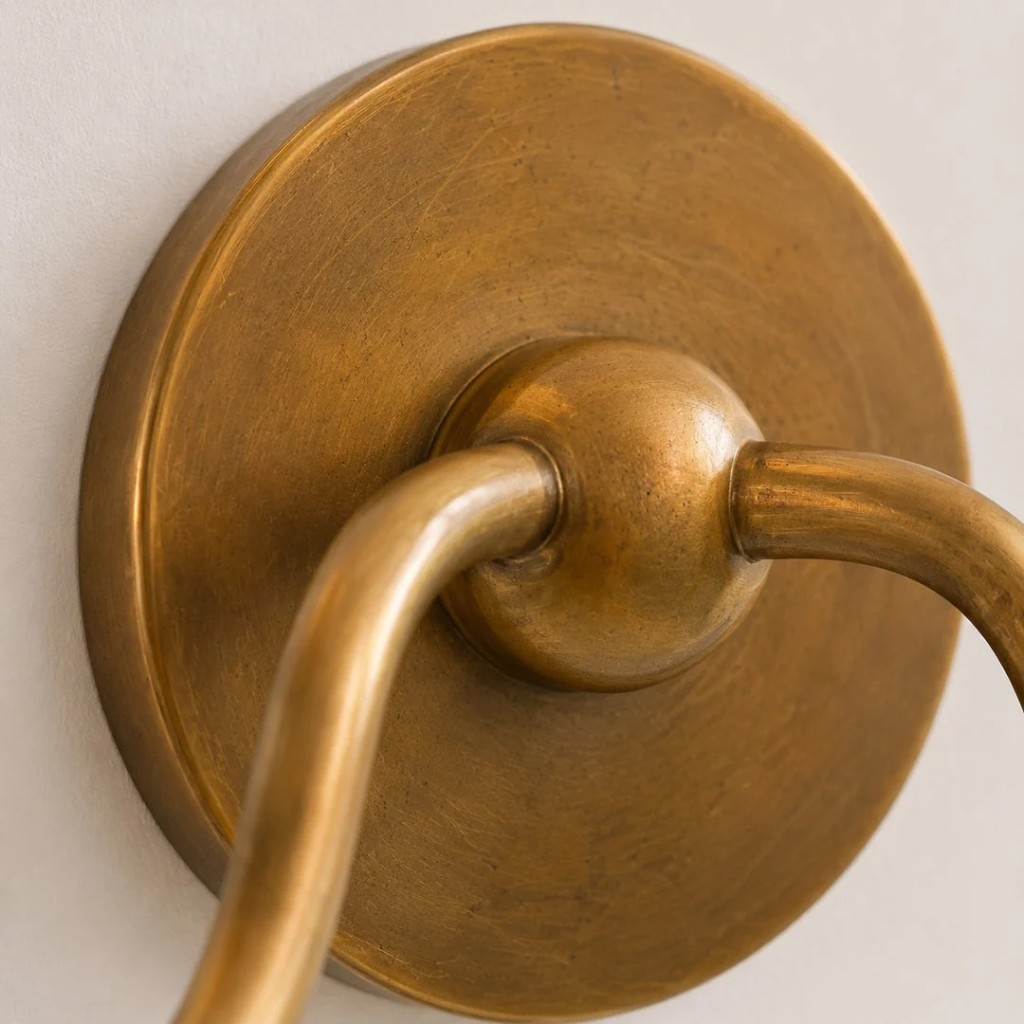 Detailopname van de ronde messing achterplaat en het armgewricht.