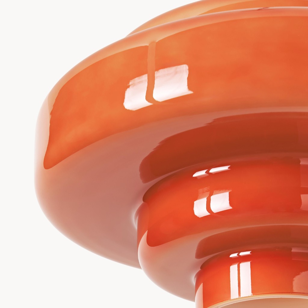 Detailopname van de glanzende oranje, gelaagde glazen lampenkap.