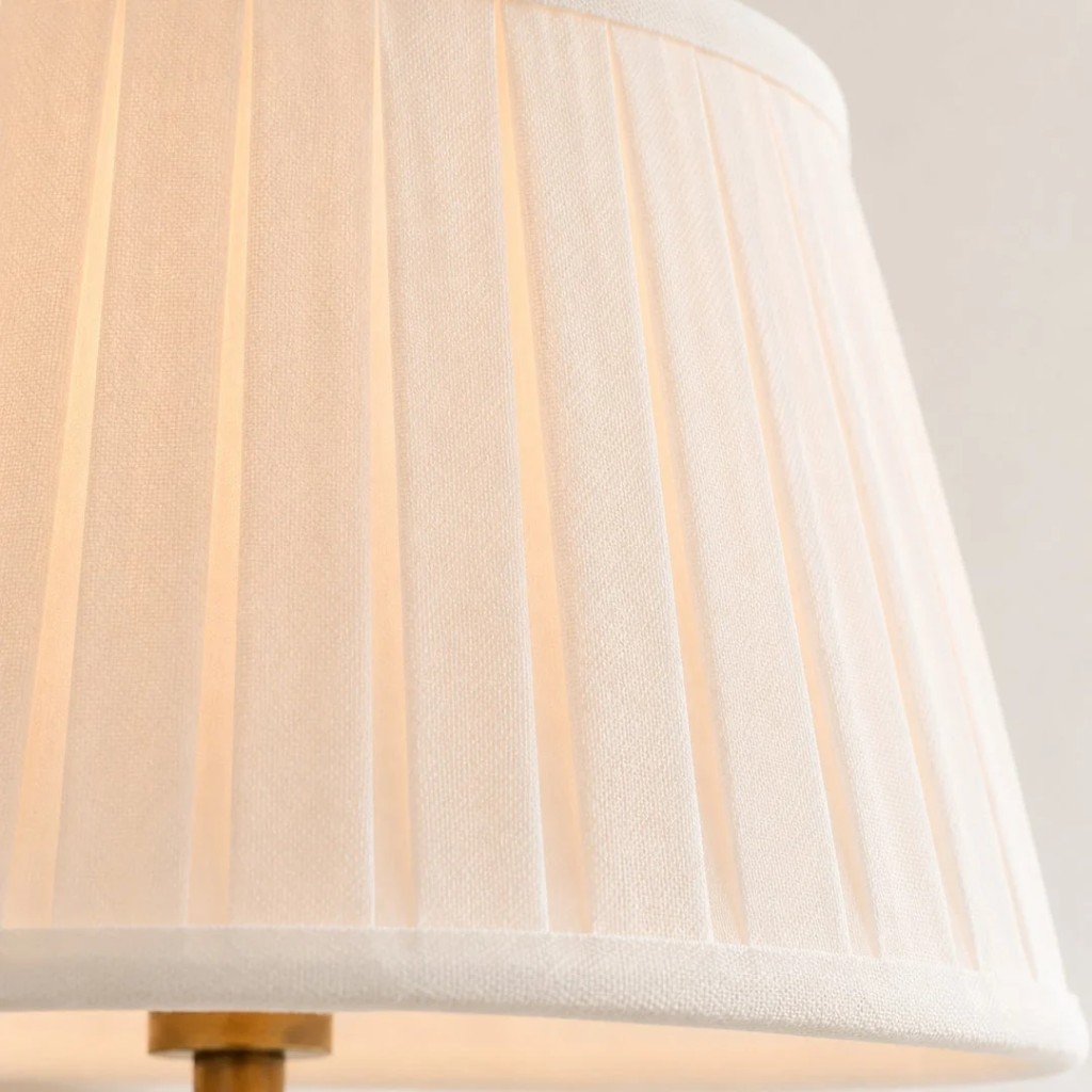 Detailopname van het verlichte, witte, geplooide linnen scherm.