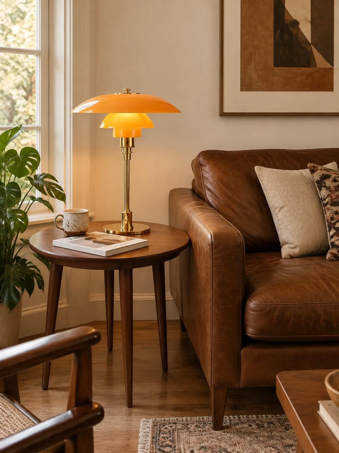 Lampe de table danoise ambre et or près d'un canapé en cuir