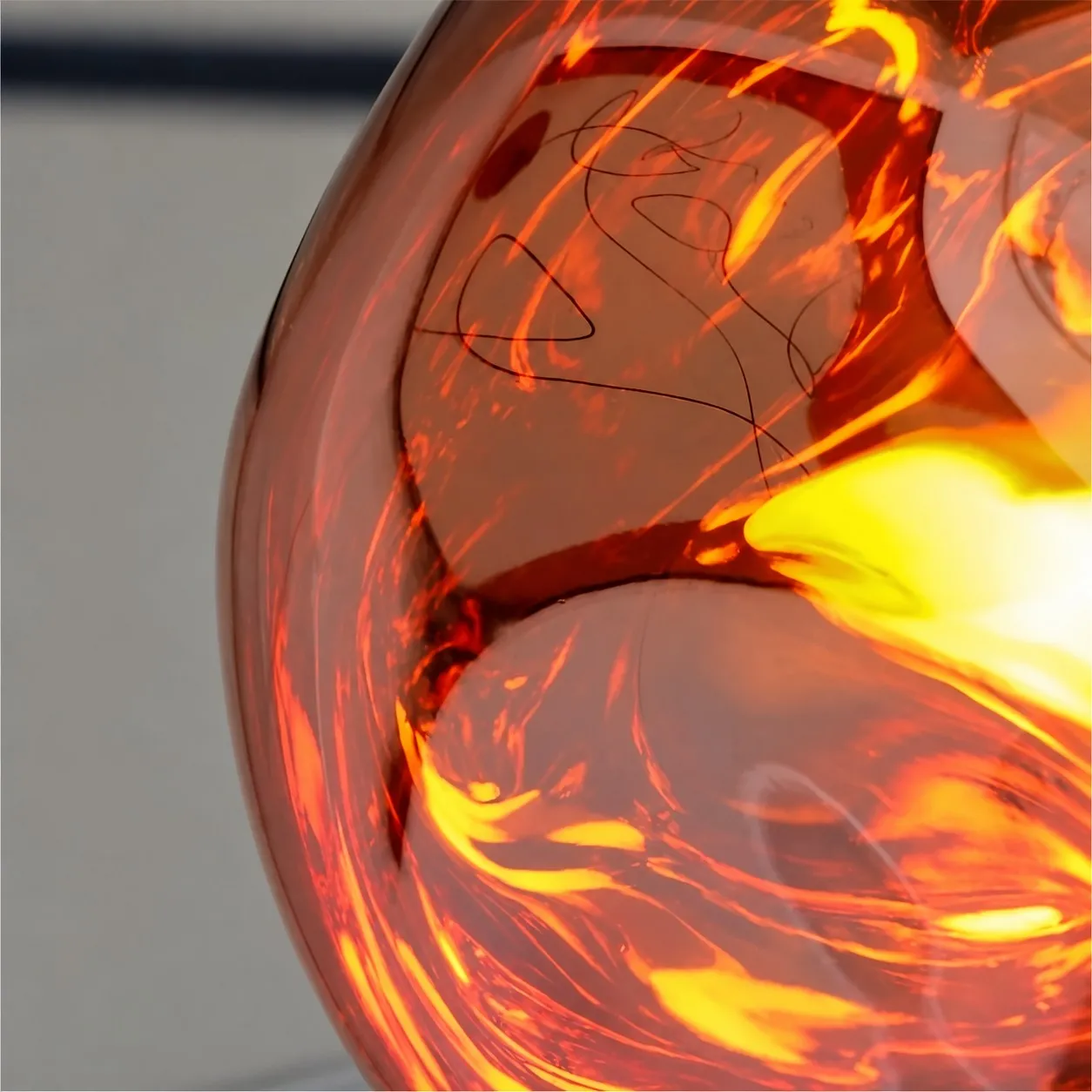 Gros plan de la surface ondulée allumée de la suspension Molten Form rouge