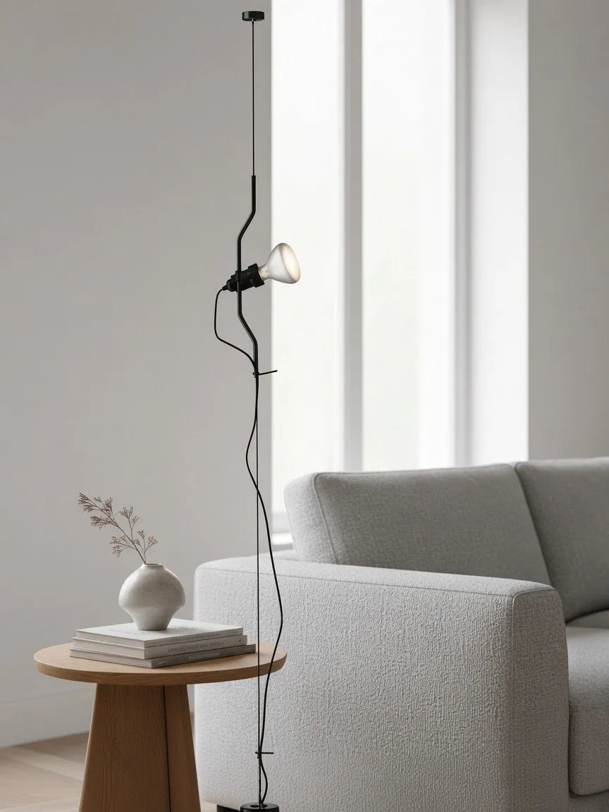 Lampadaire à câble noir près d'un canapé et d'une table d'appoint en chêne
